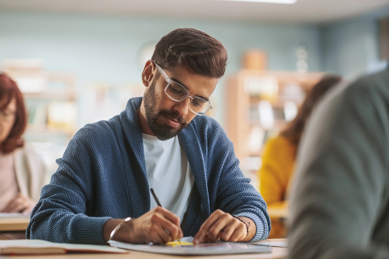 A non-traditional student writing in class. 