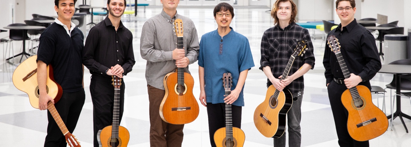 Six guitar players pose in the artirum of the Center for the Arts. 