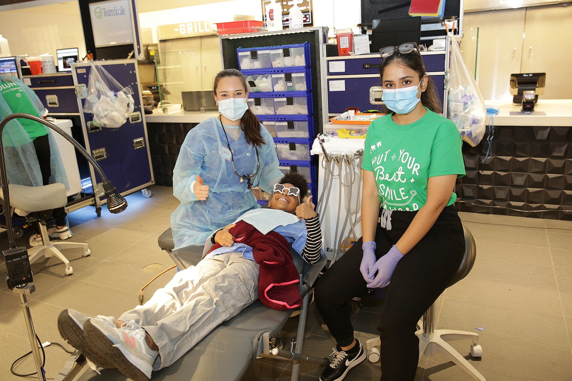 Dental students work with a young patient in a clinic setting. 