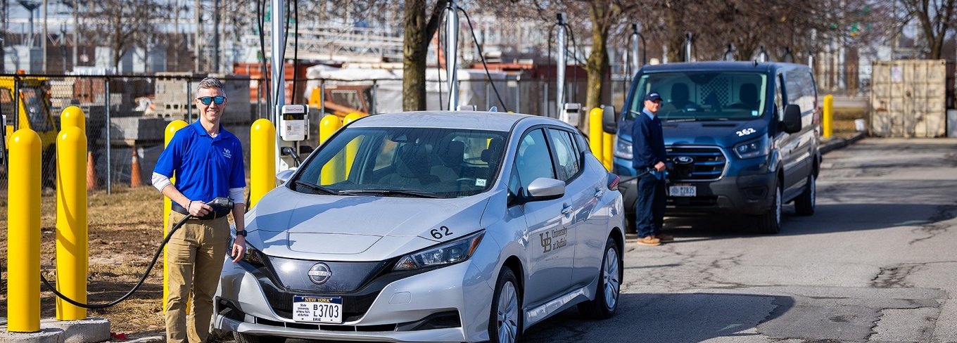 Zoom image: Nate Bolt, assistant director of construction delivery in UB Facilities, gets ready to charge up one of the university&rsquo;s fleet electric vehicles at the new station in the Beane parking lot. Photo: Douglas Levere/University at Buffalo 