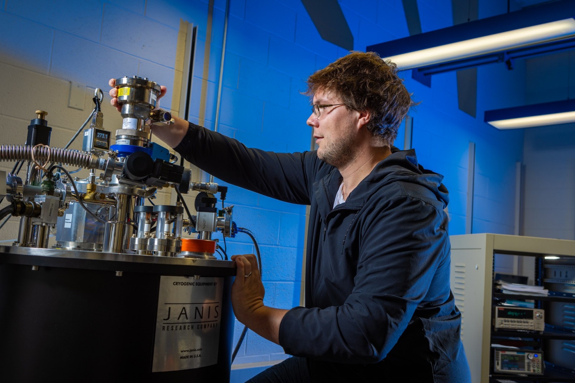 Zoom image: Jerla works with cryogenic equipment. The team's lab work involves probing the unique electrical properties of materials that can be used to build neuromorphic computer chips. Photo: Douglas Levere/University at Buffalo 