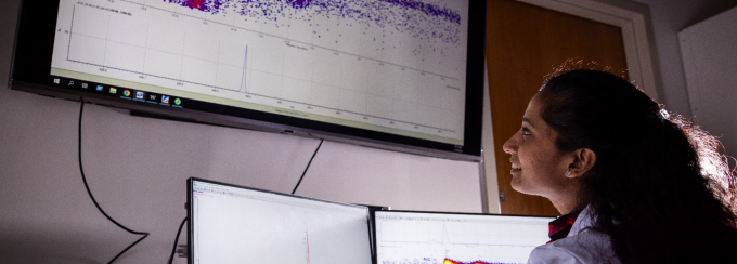 Zoom image: PhD student Mindula Wijayahena, a member of UB faculty member Diana Aga's lab, analyzes an image showing the bacteria's biodegradation of a forever chemical. Photo: Meredith Forrest Kulwicki/University at Buffalo 