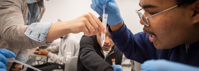 A professor helps a student work in a lab. 