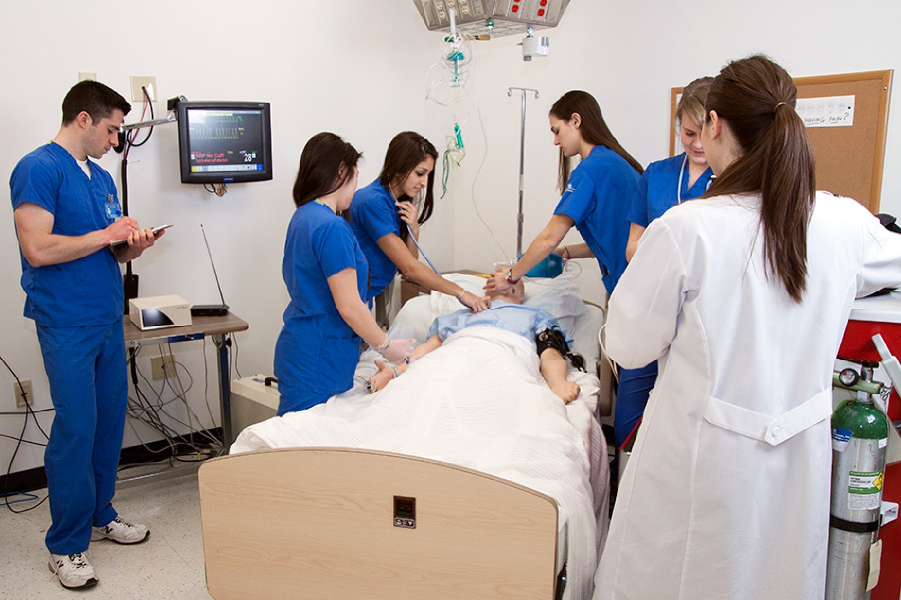 Nursing students perform a simulation on a dummy patient. 