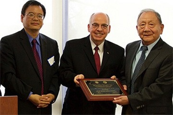 Jiyuan Yu and Stephen Dunnett present the Confucius Educator Award to George Lee. 