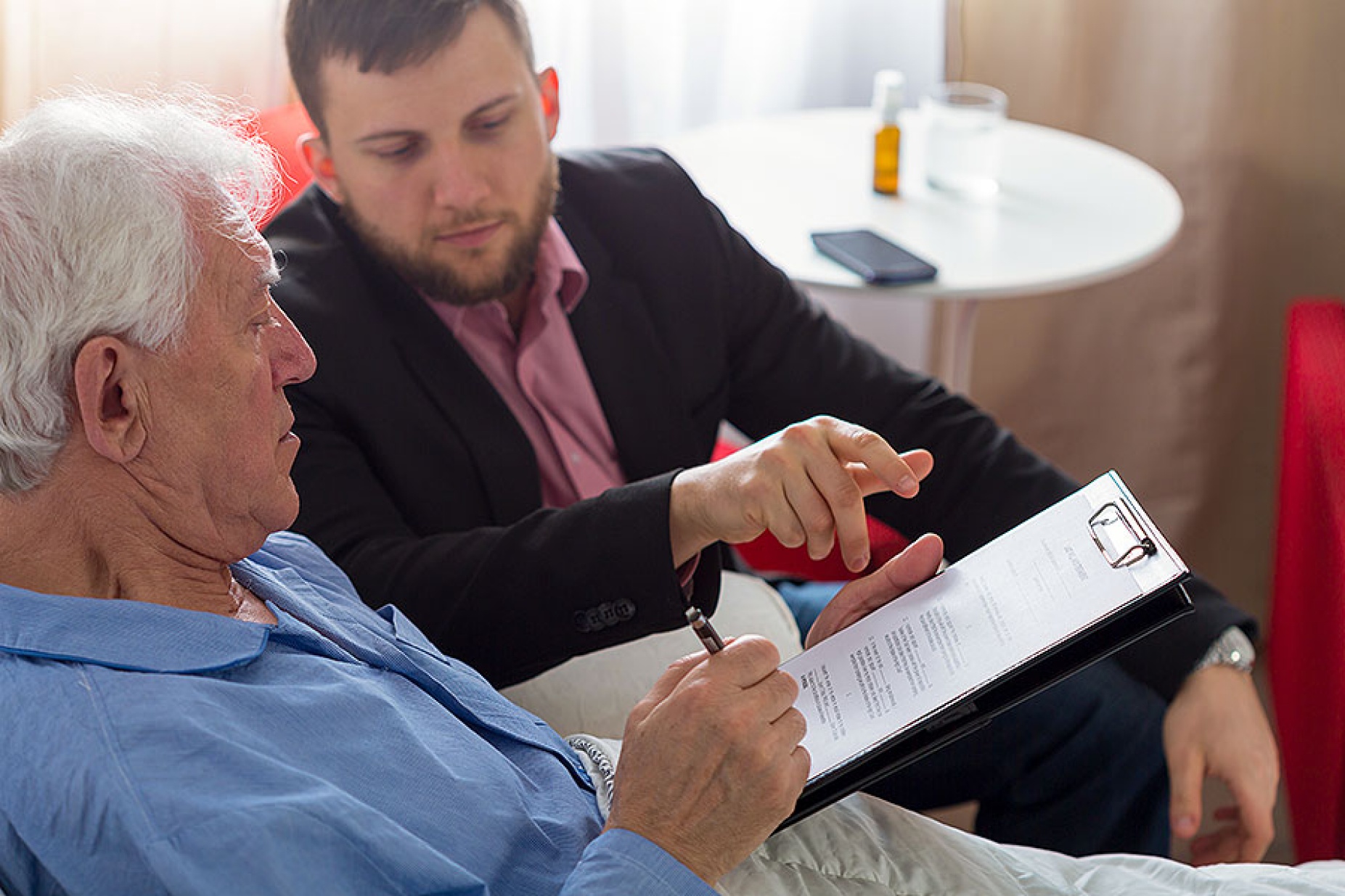 Patient in bed with adviser at his side. 