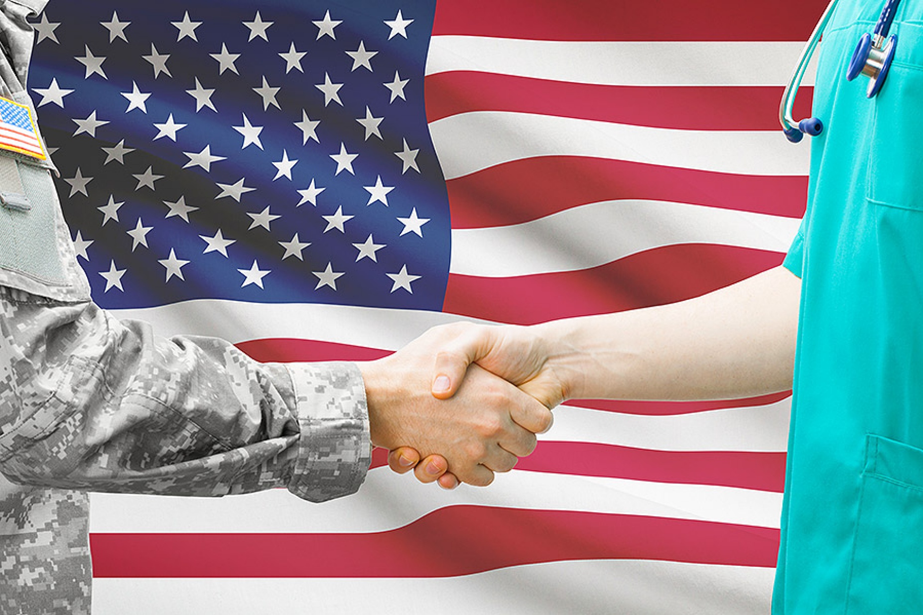 soldier and civilian hold hands in front of US flag.