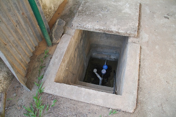 Zoom image: A municipal water meter is installed on a water pipe that is feeding water to a home. Many homes have their own wells and some rely on water that is piped in from the municipality; others use a combination of the two delivery methods, depending on certain times of the year and water availability. 