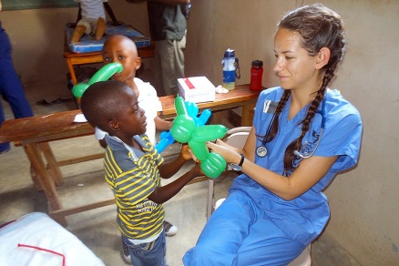 Zoom image: Medical student Christine Robertson makes a balloon dog for a Haitian girl who visited the clinic. 
