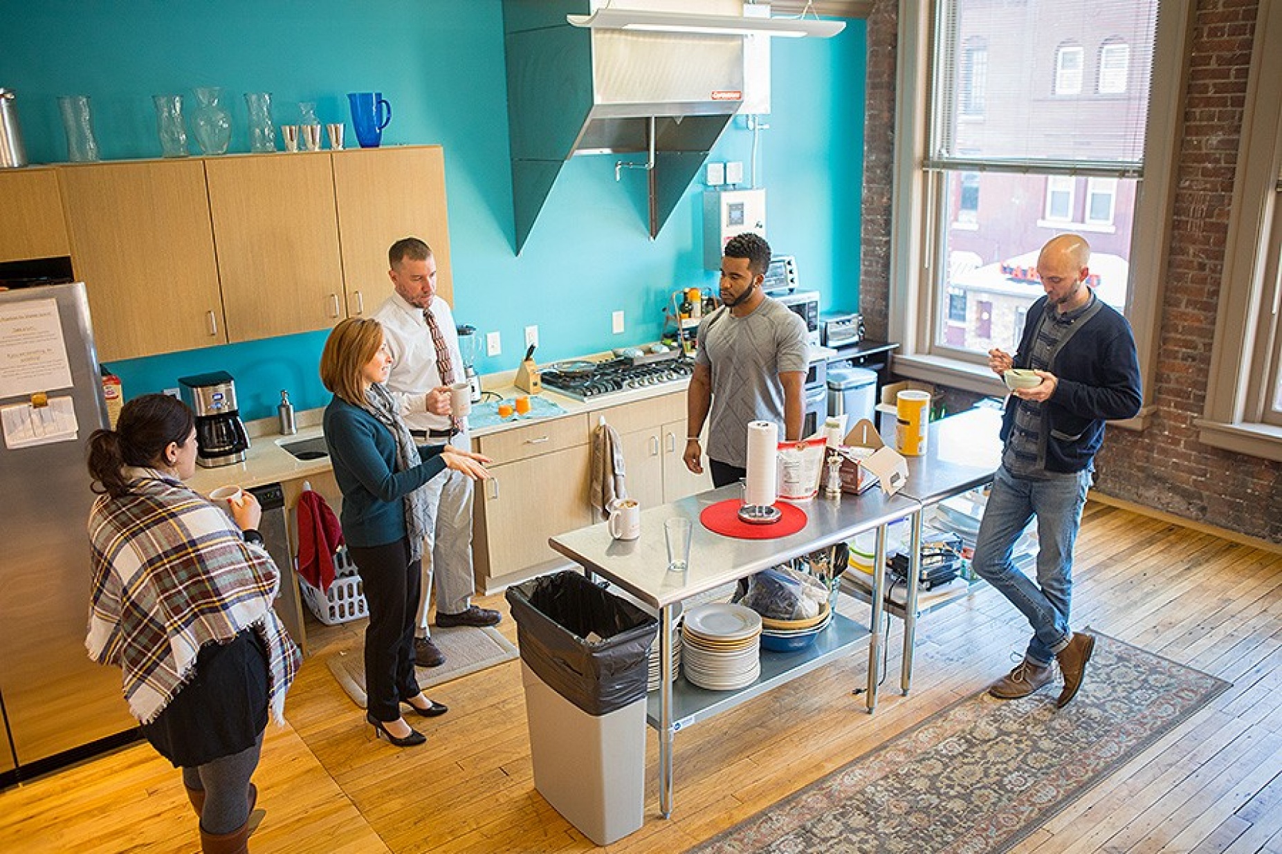 PLS 3rd Learning employees enjoying the kitchen — complete with a six-burner stove — that was added during a recent expansion of the firm’s Main Street headquarters.