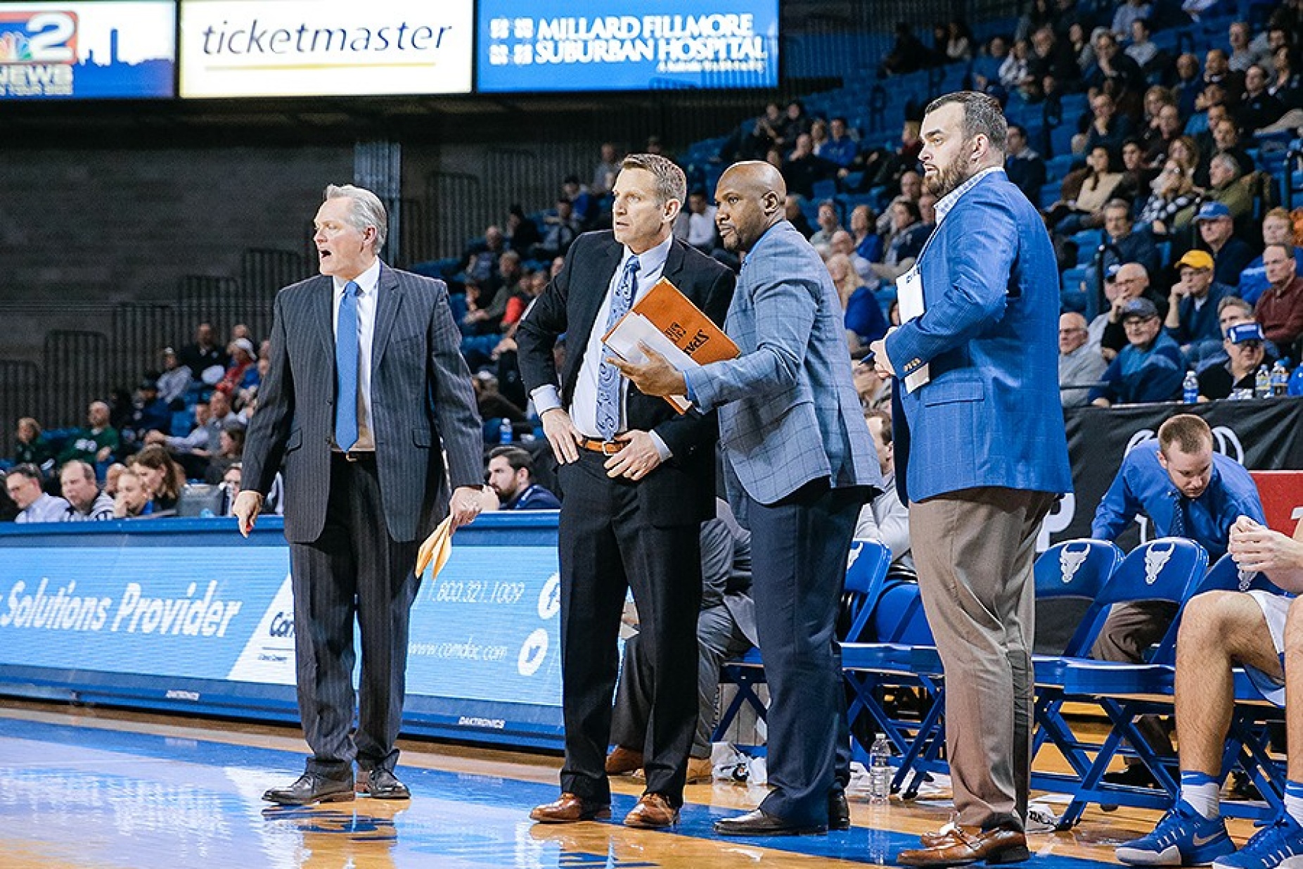 Lindsey Hunter and other coaches huddle during a game. 