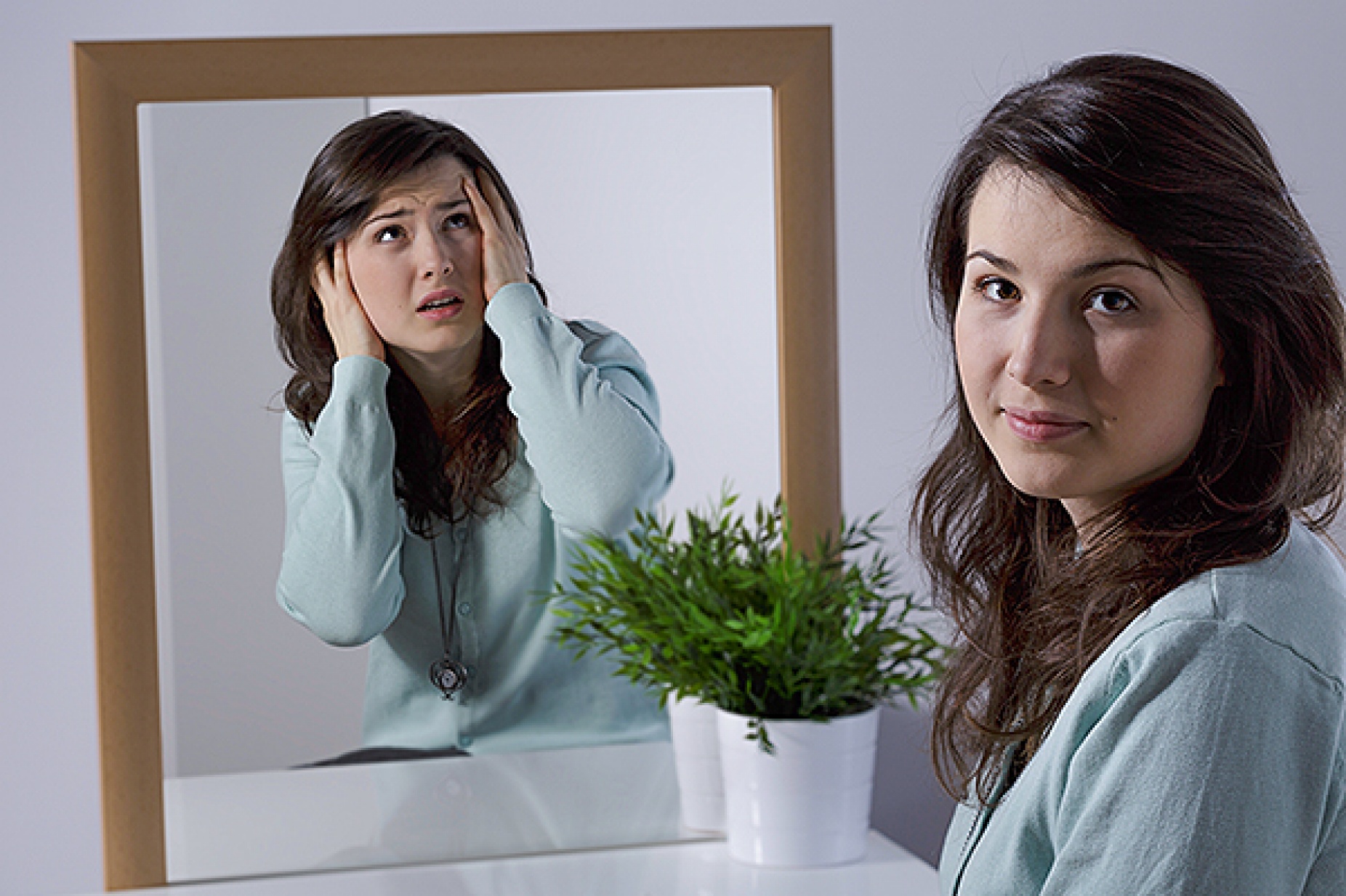 Calm women with a mirror; her image in the mirror is frantic. 