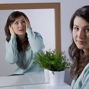 Calm women with a mirror; her image in the mirror is frantic. 