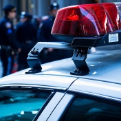 close-up of police car lights with a group of police in the background. 