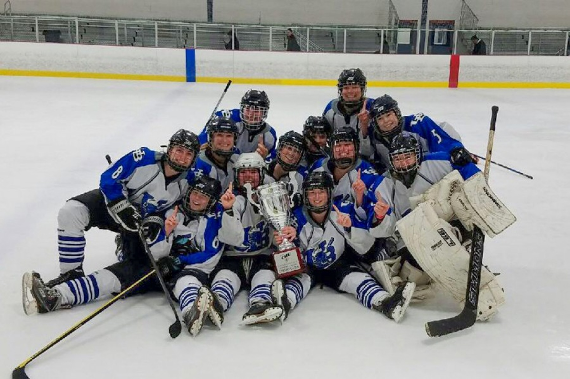 Group photo of the Women's Club Ice Hockey team on the ice. 