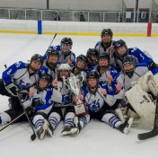 Group photo of the Women's Club Ice Hockey team on the ice. 