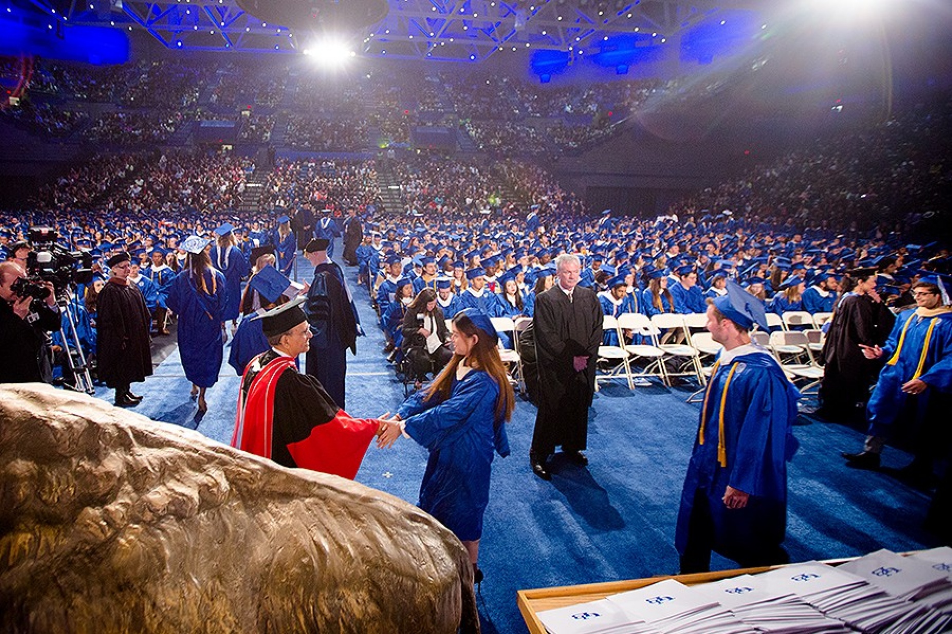 William Regan keeps a watchful eye on the student as they are congratulated by President Tripathi. 