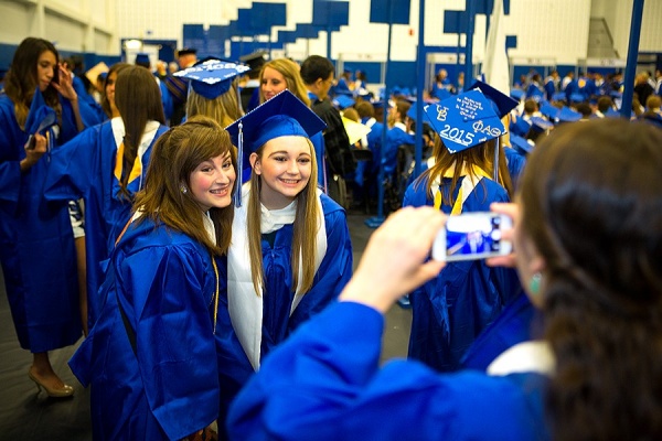 Zoom image: College of Arts and Sciences students take a photo in the robing room before marching into the main gym of Alumni Arena for the commencement ceremony. Photo: Douglas Levere 