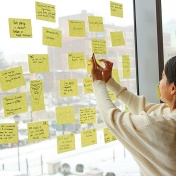 A researcher posts her note to the window at the 2017 Creative Scientist Workshop. 