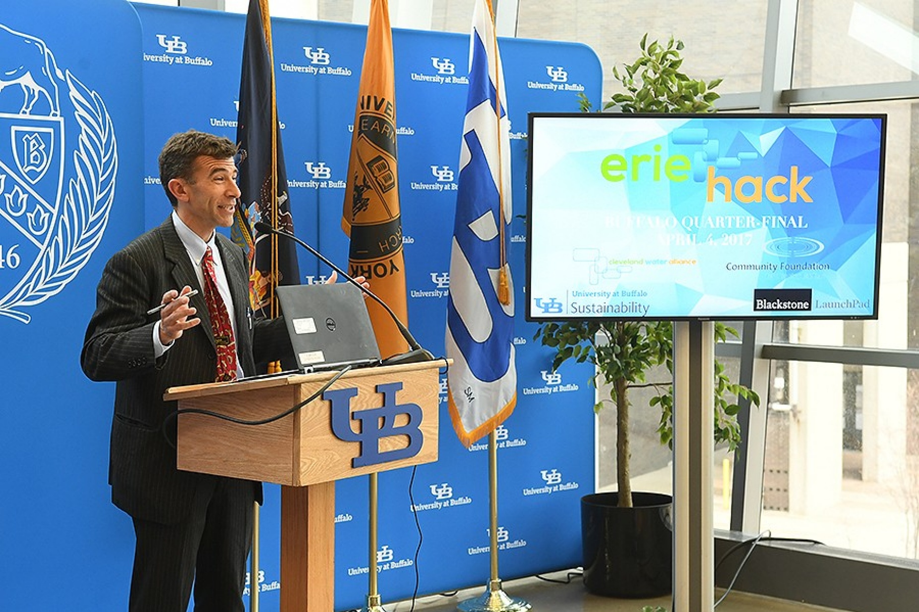 Ryan McPherson, speaking at a podium at the beginning of the ErieHack competition. 