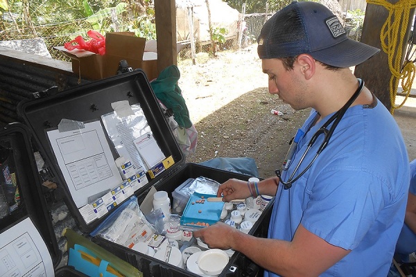 Zoom image: Medical student Christian Curatolo counts out pills. 