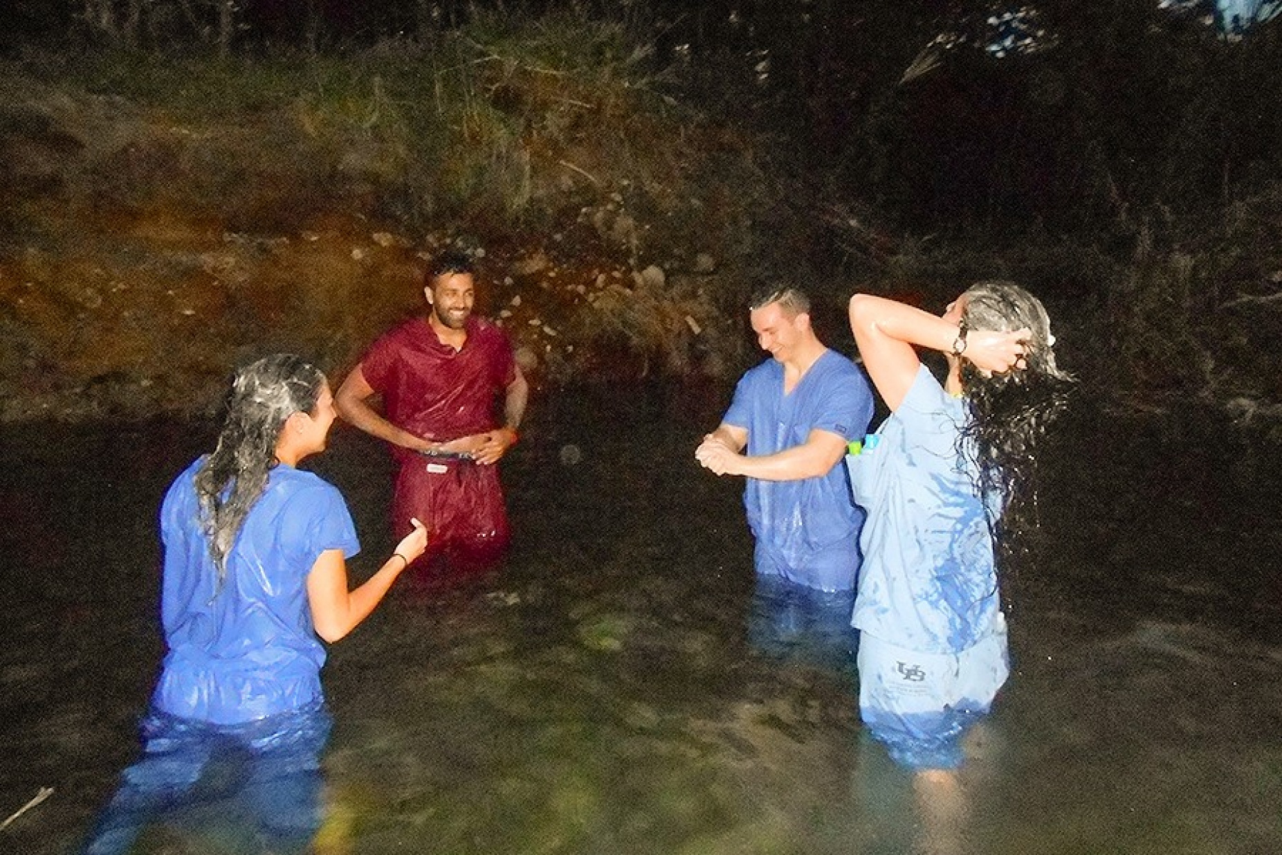 Team members scrub up in the nearby river wearing their scrubs.