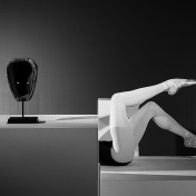 Brendan Fernandes. As One IX, 2017. Photograph on paper. Courtesy of the artist. African mask sitting near mannequin legs in ballet slippers. 