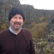 photo of Michael Mann in front of a rocky cliff. 