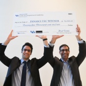 Panasci winners Parham Rohani and S. Bruce Kohrn holding up a big check that reflects their winnings for taking first place. 