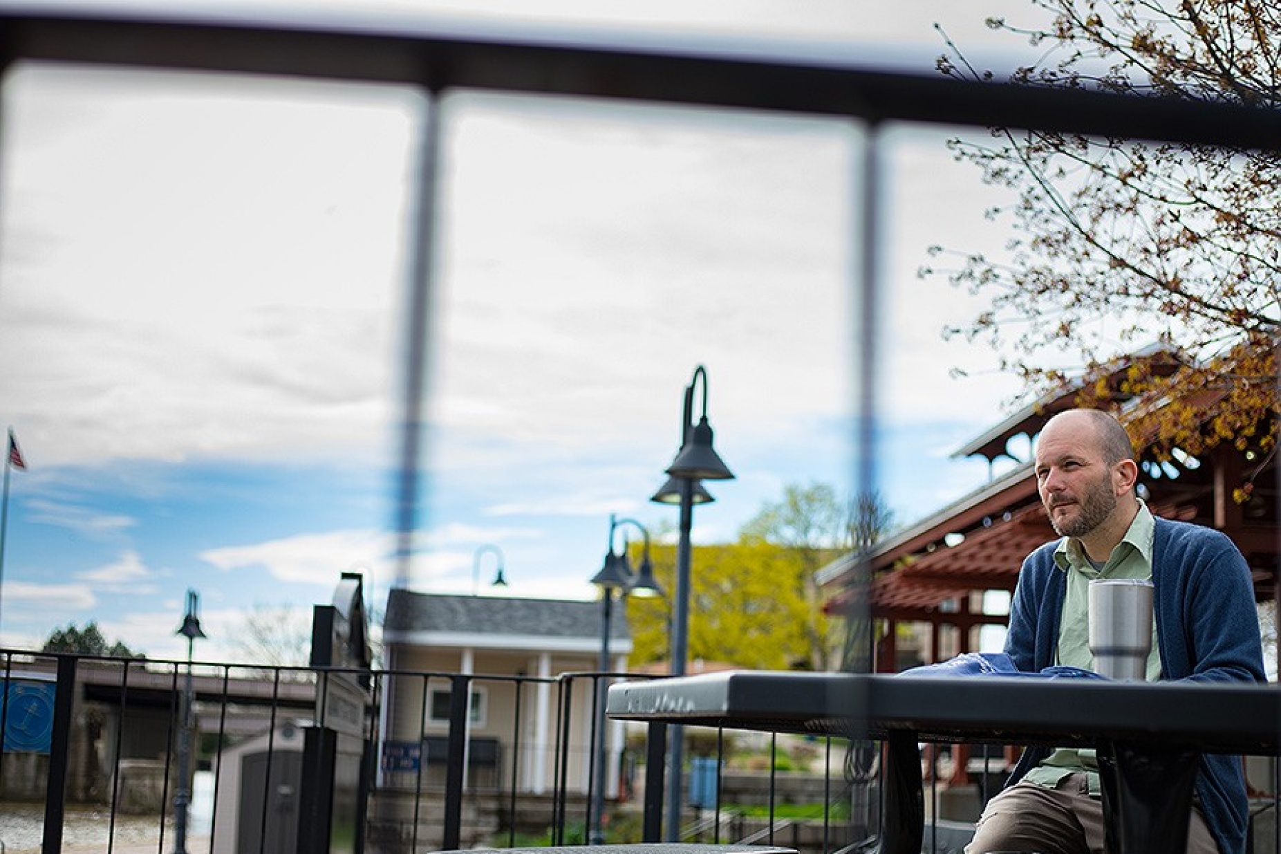Dennis Reed, sitting at a table at Gateway Harbor Park while sketching. 
