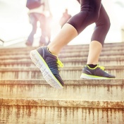 Close up on a person's sneakers as they run up stairs. 