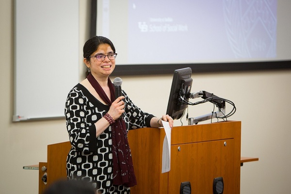 Pavani Ram at the lectern, microphone in hand. 