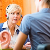 Woman wearing headphones taking a hearing test. 