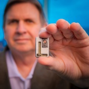 Efferent Labs founder holding up tiny implantable device. 