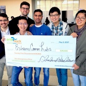 photo of ExtremeComms Lab team members holding a big check for $15,000 they received after placing second in Erie hack finals. 