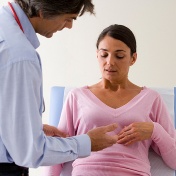 A female patient consults with a doctor about abdominal pain. 