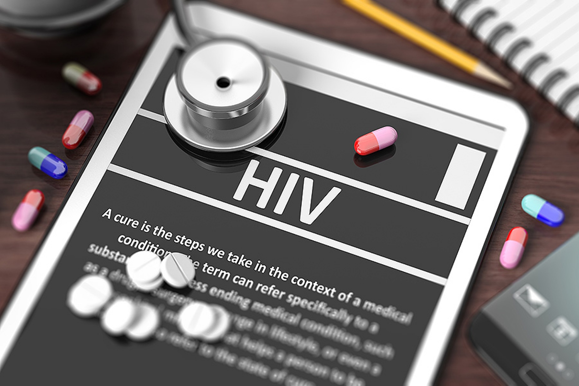 Tablet with "HIV" on screen, stethoscope, pills and objects on wooden desktop. 