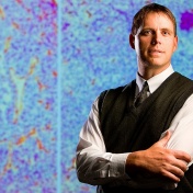 shot of Joseph Balthasar with image of cell in the background. 