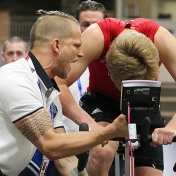 picture of Jordan Marwin shouting encouragement at a young hockey player on a stationary bike. 