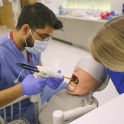 dental student working on a "patient" in the pre-clinical simulation center. 