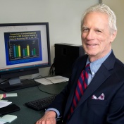 Photo of Leonard Epstein at his desk, with computer in the background. 