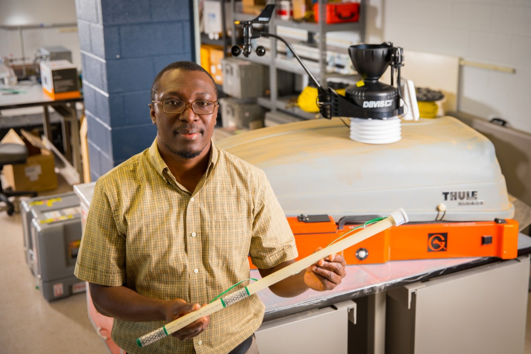 Erasmus Oware holds a multiple-depth soil moisture probe in his laboratory. 