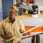 Erasmus Oware holds a multiple-depth soil moisture probe in his laboratory. 
