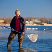 Helen Domske holding a net and standing in Lake Erie at Woodlawn Beach State Park. 