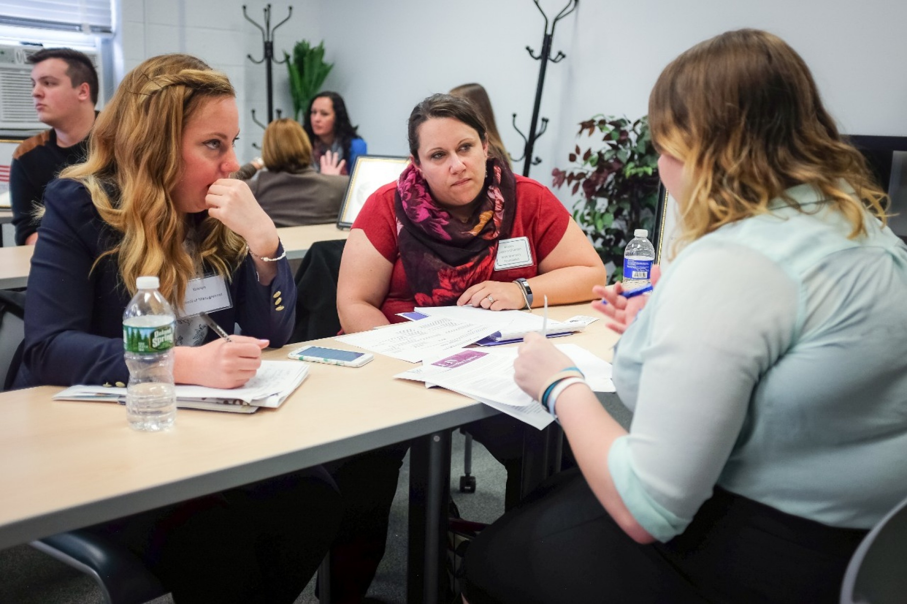 UB students discuss their project with a staffer from the WNY Women&rsquo;s Foundation during the Social Impact Fellows orientation. 