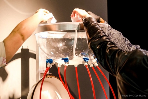 Zoom image: After rinsing their mouths with a saline solution, visitors pour the solution into a spittoon that comingles the DNA of hundreds of people. 