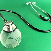 Stethoscope on a crystal globe with a green background. 