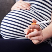 Pregnant woman hold a cigarette. 