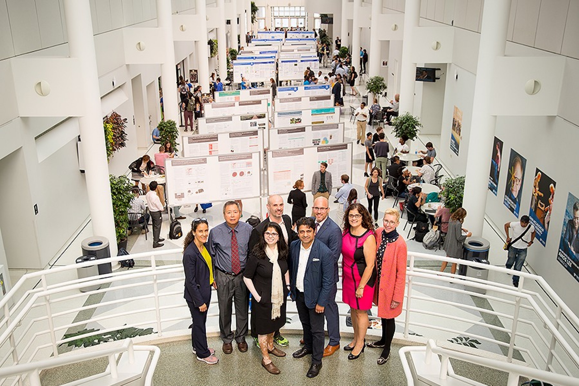 Leaders of the GEM, GHE and SMART communities of excellence pose in front of the posters presented at the annual progress review. 