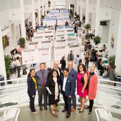 Leaders of the GEM, GHE and SMART communities of excellence pose in front of the posters presented at the annual progress review. 